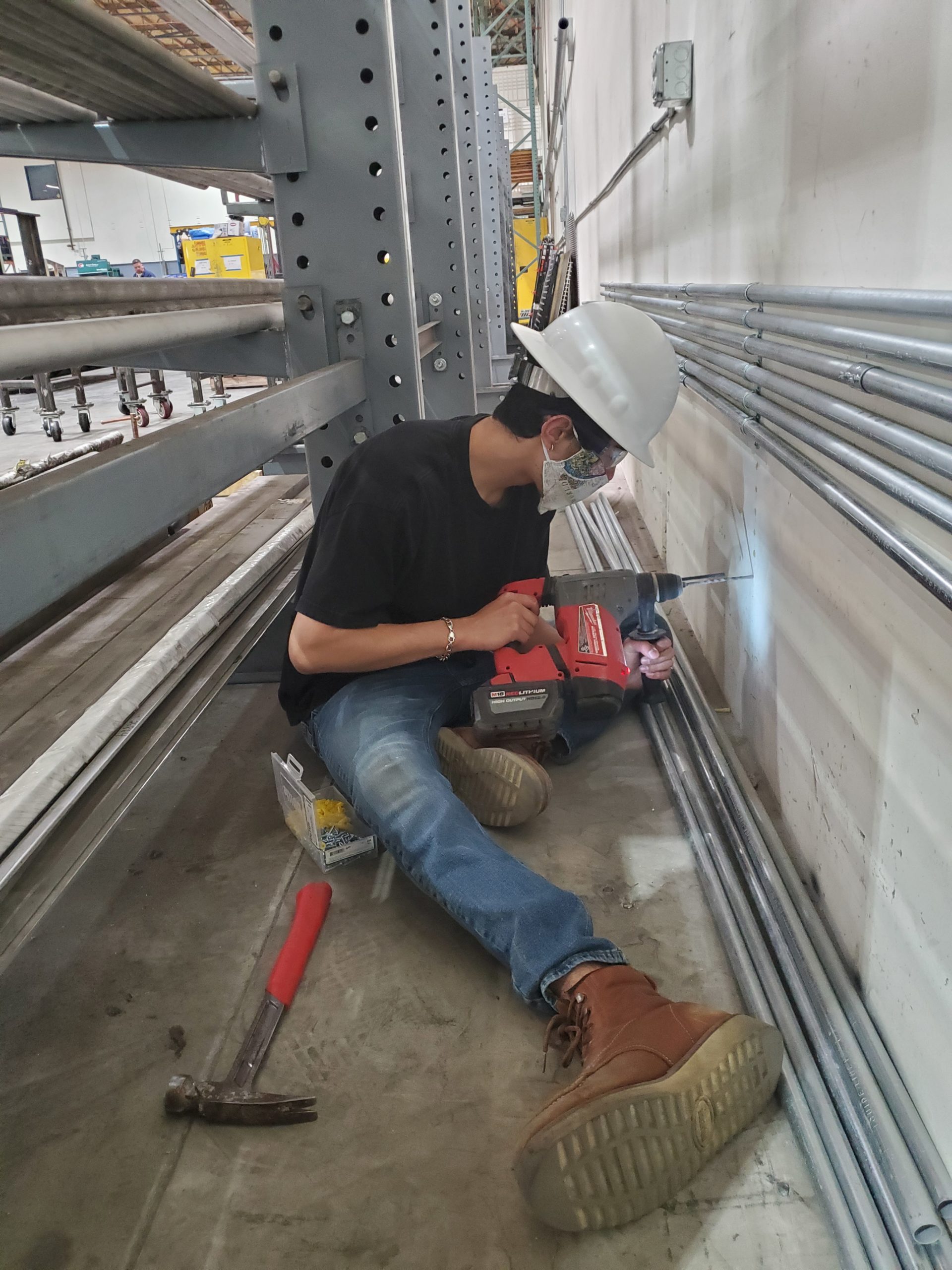 Electrical contractor sitting down while using a power tool
