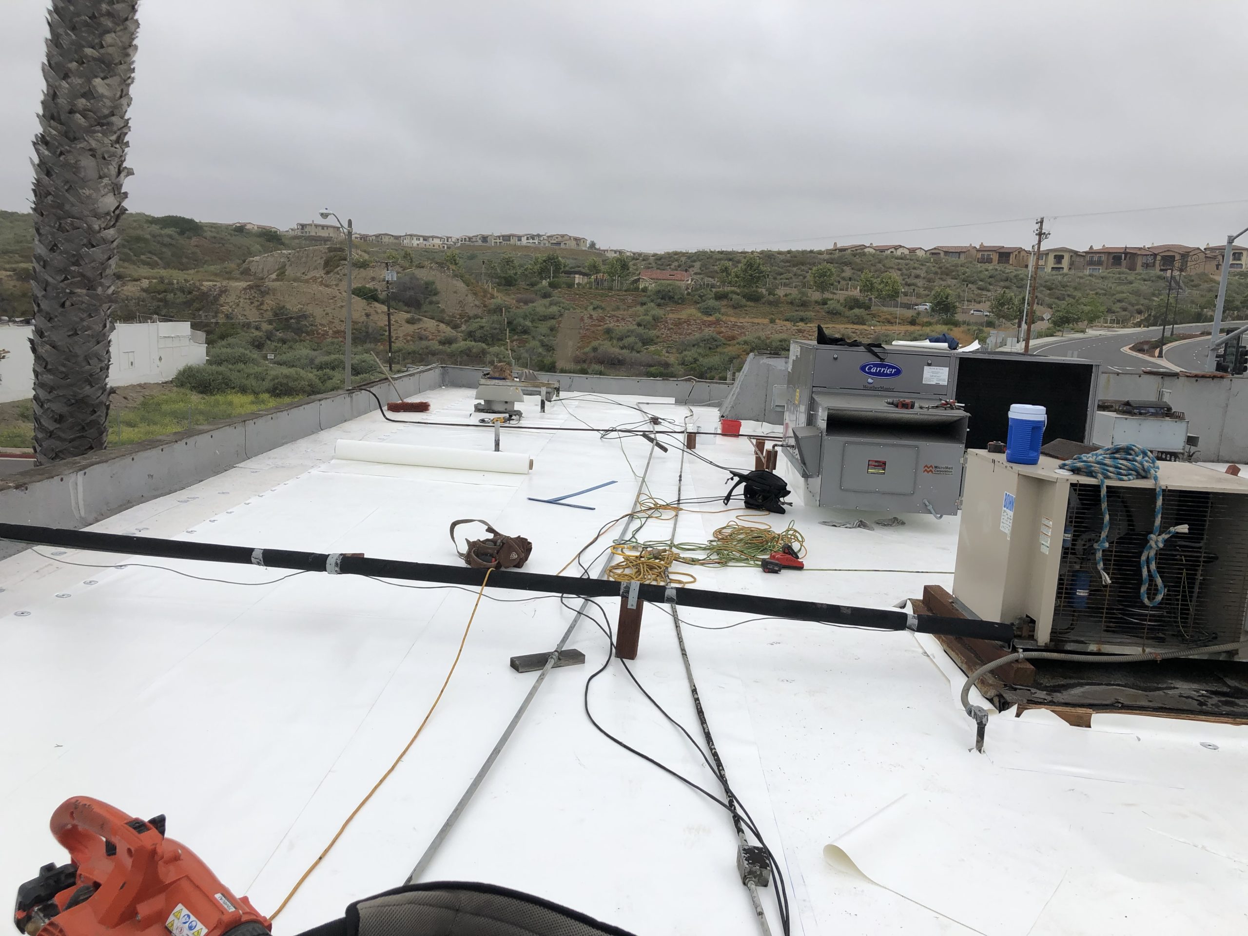 Several tools and cords on top of a commercial building's cool roof