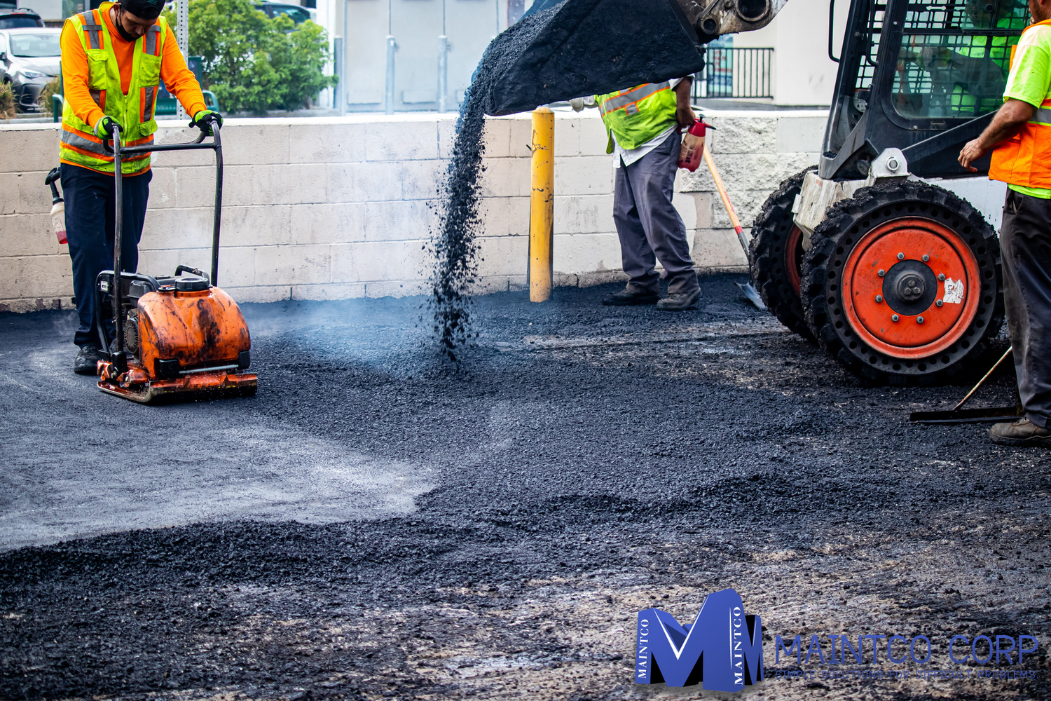 Maintco employees pouring asphalt to pave a parking lot