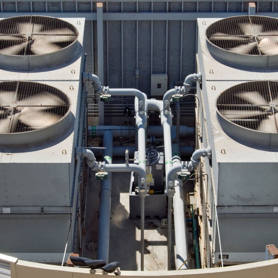 Image of a commercial HVAC (Heating, Ventilation, and Air Conditioning) system, showing the equipment and ductwork installed in a commercial building, responsible for regulating temperature and air quality.