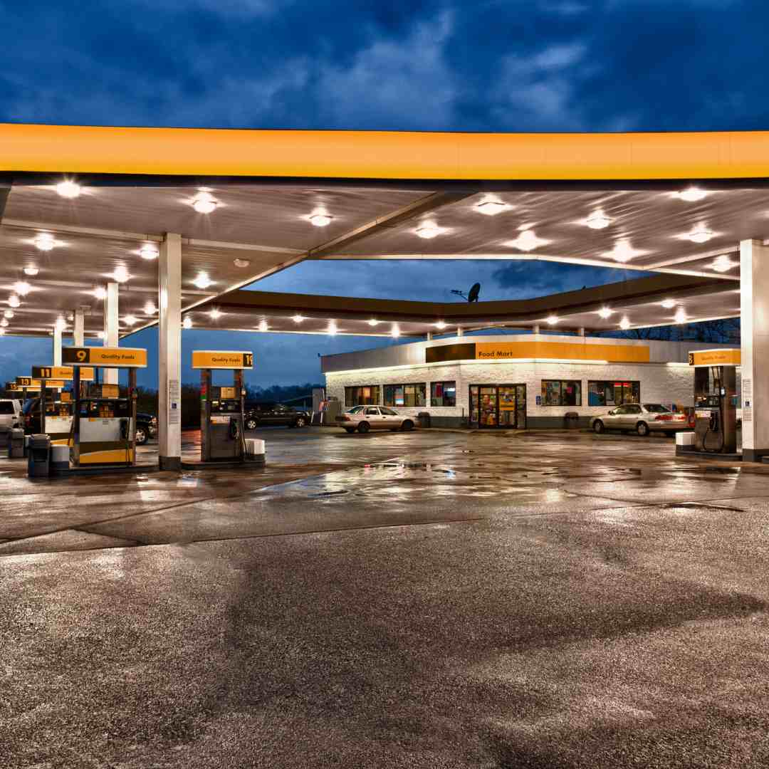 Image of a commercial gas station service location with fuel pumps, convenience store, and signage.