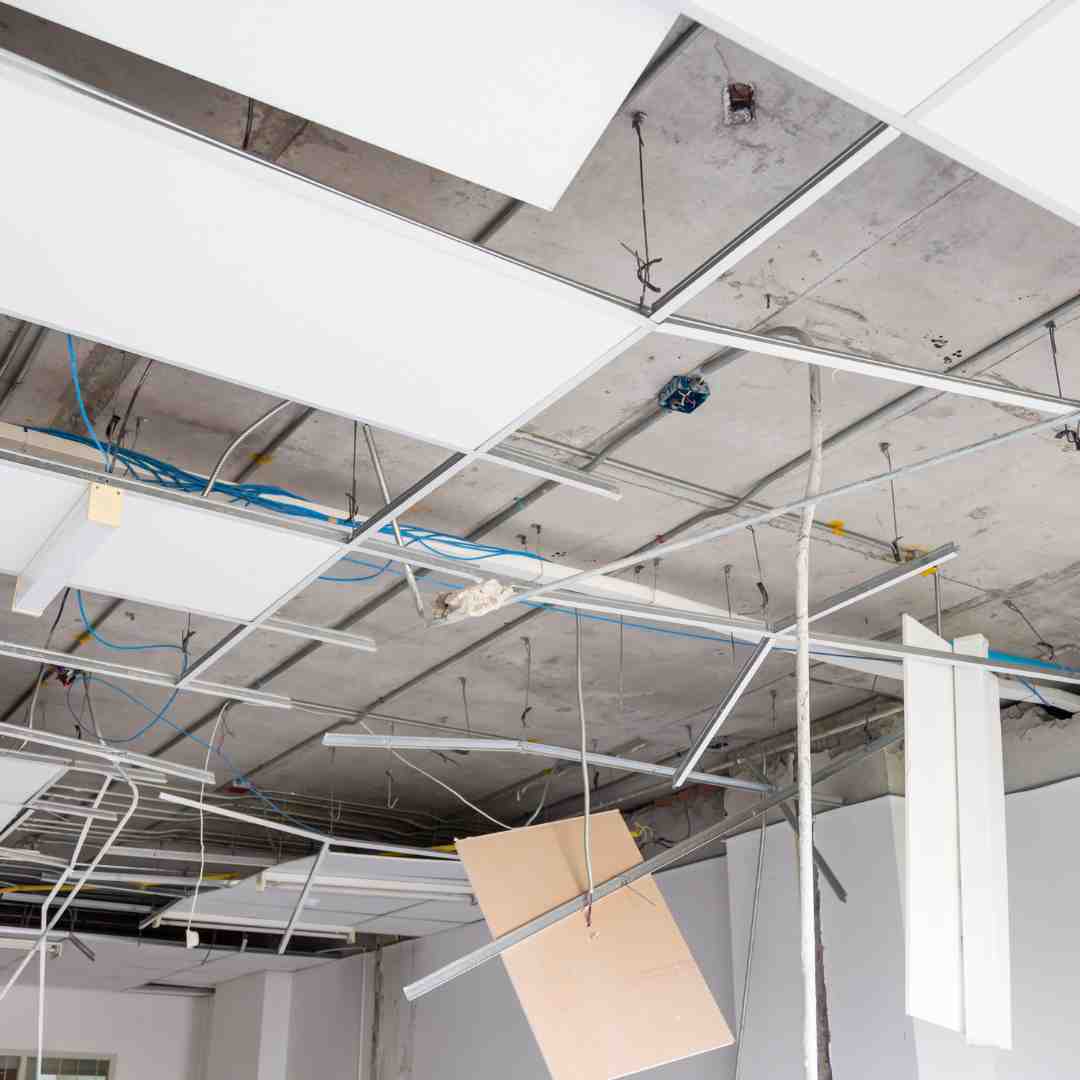 A maintenance worker repairing the lighting fixtures during a tenant improvement project in a commercial space.