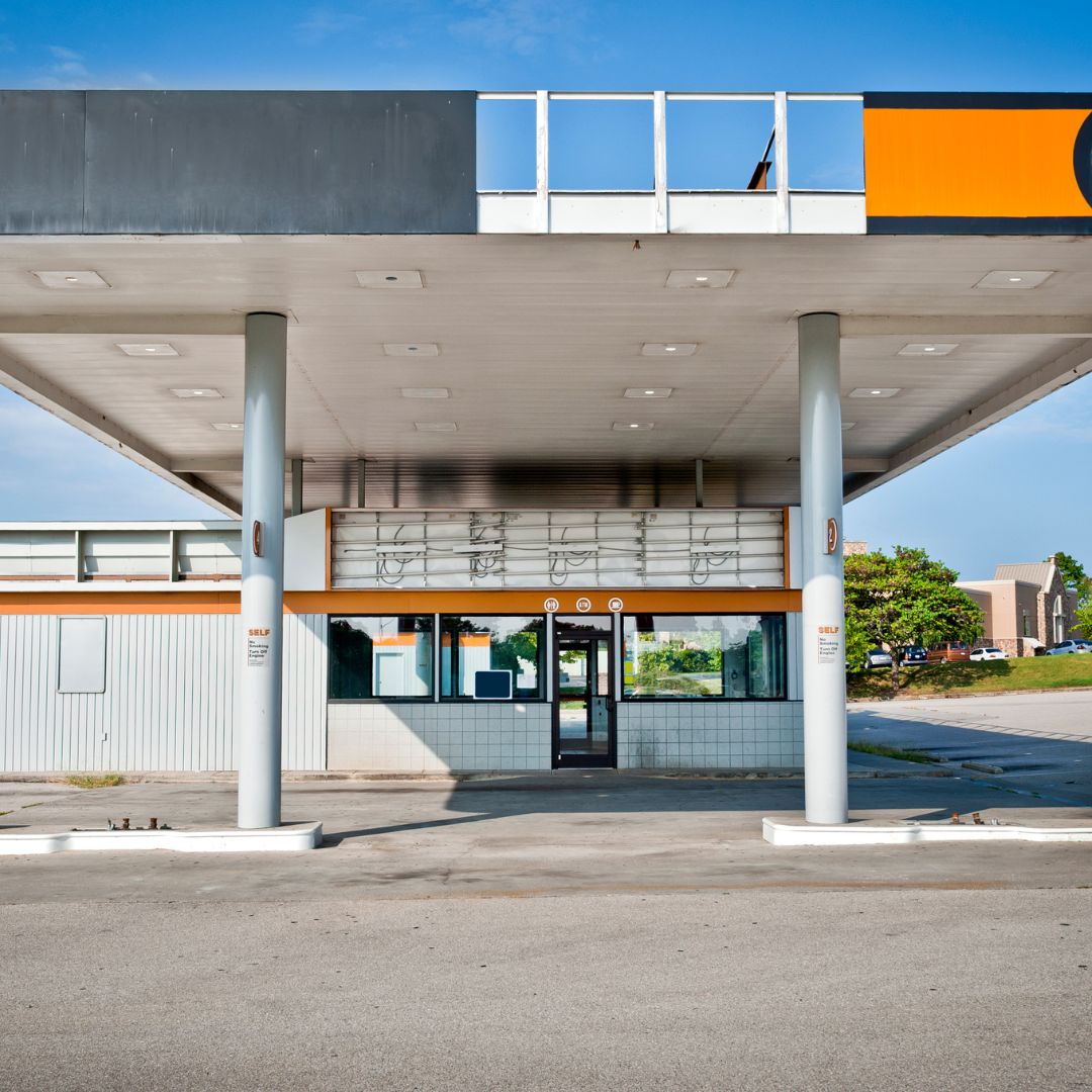 A convenience store interior with worn-out fixtures, outdated signage, and faded paint. The store appears in need of a remodel, with an opportunity for improvement in its aesthetics and functionality."