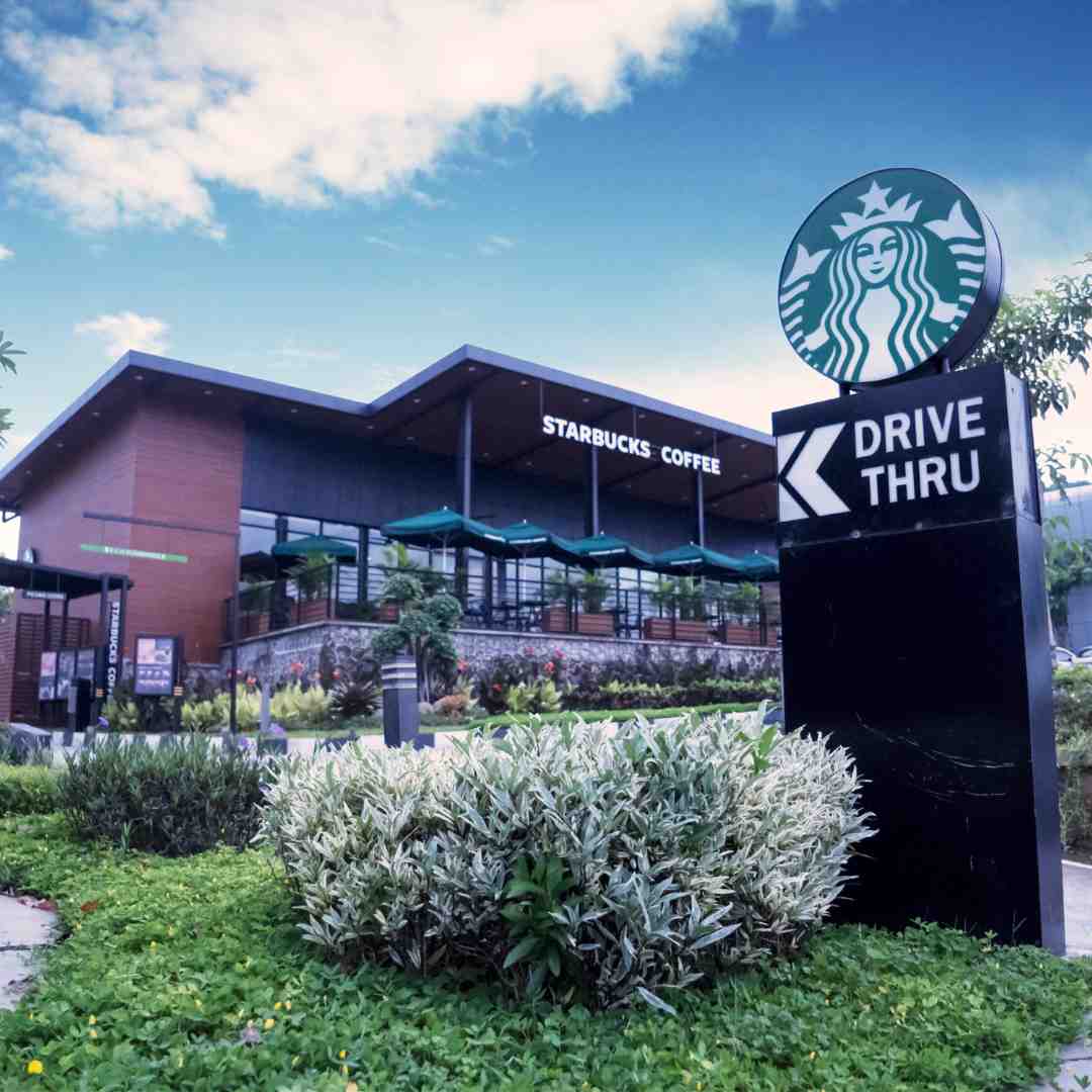 Image of a Starbucks store, featuring the iconic green logo and outdoor seating area with customers enjoying their beverages